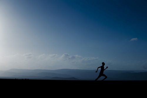 Person running in blue landscape