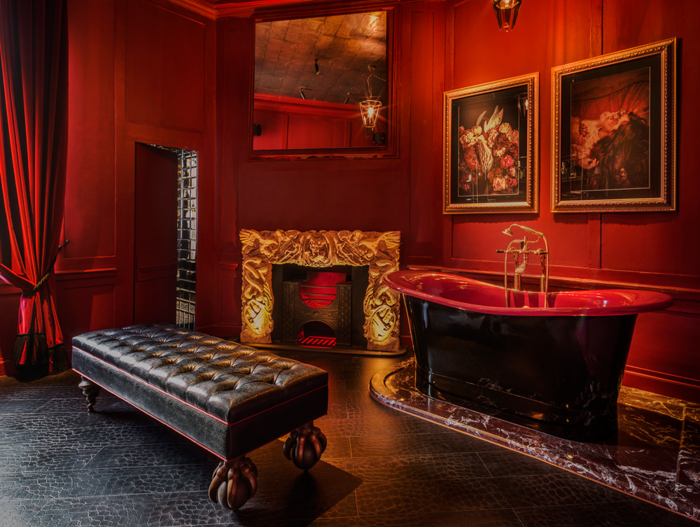 luxurious red guest bathroom with roll top bathtub at Chateau Denmark hotel in London